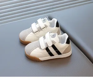 Detail of baby sneakers featuring dual velcro straps and durable brown gum soles