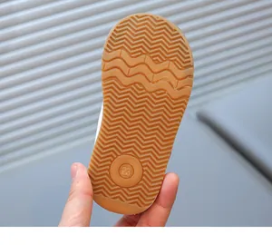 Macro shot of brown rubber anti-slip wave sole showing size 23 on toddler shoes