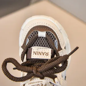 Vista macro de malla transpirable y cuero empalmado en las zapatillas infantiles con cordones