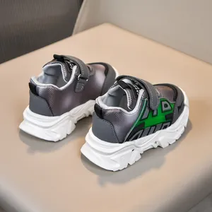 Détail de baskets argentées pour bébé avec touches vertes et fermeture velcro