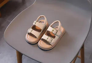 Top view of beige children's sandals with double straps and gold adjustable metal buckles