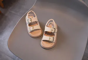 Detail view of beige toddler sandals with dual gold buckles and soft non-slip soles