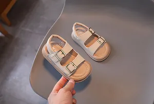 Detail of beige children's sandals with adjustable metal buckles and soft leather texture