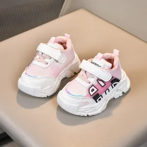 Détail des baskets bébé rose et blanc avec bande velcro sur un siège beige