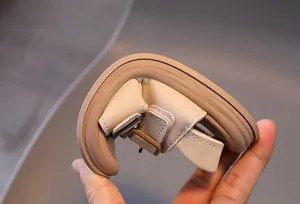 Macro shot of a beige children's sandal showing the flexible soft sole being bent easily