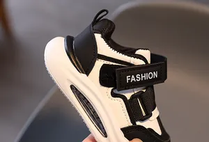 Detail der Kinder-Sneaker mit doppeltem Klettverschluss und modischem Schriftzug auf Leder