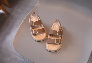 Detail view of brown leather kids sandals with gold metal buckles and anti-slip soft soles