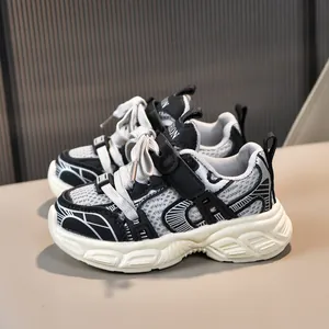 Détail de baskets en mesh respirant pour enfants avec velcro et design bicolore noir et blanc