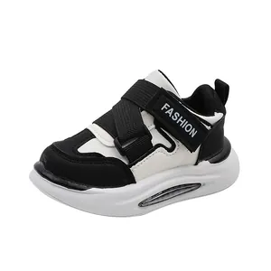 Klassische schwarz-weiße Kinder-Sportschuhe mit weicher Gummisohle und Klettverschluss
