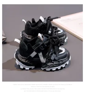 Detail of children black chunky sneakers featuring mesh leather panels and non-slip soles