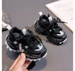 Close-up of kids' black and white dad sneakers with breathable mesh and reflective trim