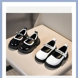 Detailansicht der Mädchen Lackleder Mary Jane Schuhe mit Strassriemen in Schwarz und Weiß