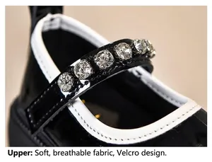 Detail von glänzenden schwarzen Lacklederschuhen für Mädchen mit Strassriemen und Klett