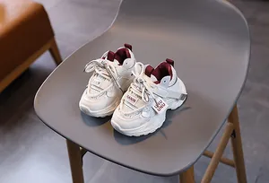 Top view of breathable mesh kids sneakers on a chair showing the burgundy inner lining