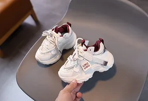 Detail of white mesh boys sneakers with burgundy accents and UNU UNU branding