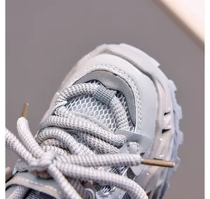 Detail of breathable mesh upper and durable synthetic leather on grey kids' sneakers