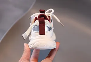 Close-up of kids mesh sneakers with burgundy accents and anti-slip thick soles