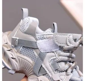 Close-up of children's grey sneakers showing breathable mesh texture and velcro strap