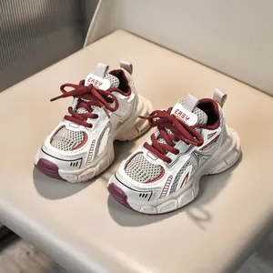 Detailed macro view of kids' chunky mesh sneakers showing breathable beige and red texture