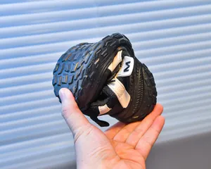 Macro detail of flexible black mesh kids running shoe being folded to show soft sole