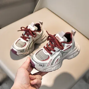 Detailed side view of breathable mesh kids sneakers in beige and white with red accents