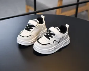 Detail view of children white sneaker showing breathable holes and embossed sole symbols