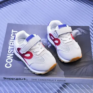 Détail de baskets en mesh respirant pour enfants blanc avec rayures rouges et velcro