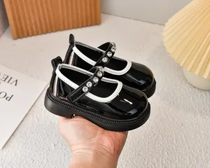 Detalle de zapatos Mary Jane de charol negro para niña con correas de diamantes