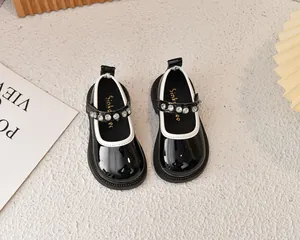 Detalle de zapatos Mary Jane de charol negro con correa decorada con diamantes de imitación