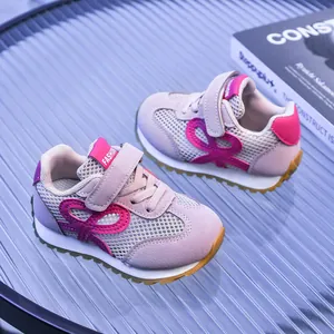Détail de baskets en mesh rose respirant avec motif papillon et fermeture à scratch enfant