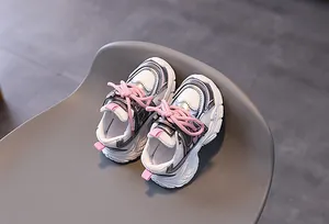 Vue détaillée de dessus des baskets épaisses en maille respirante argent et rose sur chaise