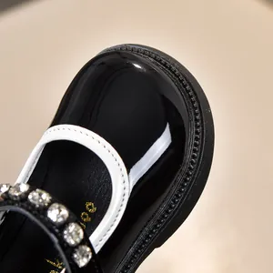 Detail von glänzend schwarzen Lackleder-Mary-Janes für Mädchen mit glitzerndem Strassband
