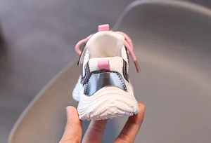 Détail arrière de basket enfant respirante avec lacets roses et semelle blanche antidérapante