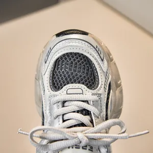 Close-up of children's mesh sneakers showing breathable texture and silver leather trim