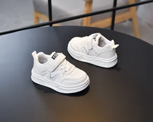 Detailed view of white kids' leather sneakers with velcro strap and non-slip rubber sole