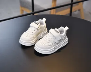Detail of children white sneakers showing velcro closure and breathable toe cap holes