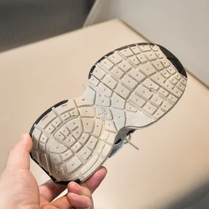 Close-up of non-slip rubber sole with texture and size 28 on kids mesh sneakers