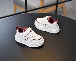Detail view of white and red children sports shoes with hook-and-loop closure