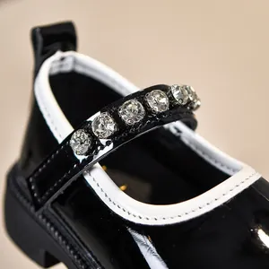 Detailansicht Mädchen Lacklederschuhe mit Strassriemen und weißem Rand in Schwarz