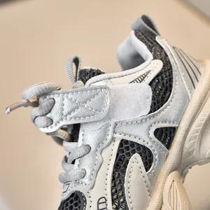 Detail of silver mesh children sneakers featuring breathable fabric and hook-and-loop strap