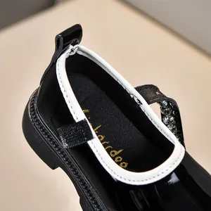 Detailaufnahme der schwarzen Lackleder-Mary Janes für Mädchen mit Strass-Riemchen