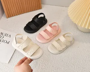 Dettaglio di sandali antiscivolo per bambini con cinturini in velcro e cuciture a X