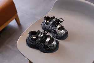 Détail de baskets noires en mesh pour enfants avec bordure argentée et semelle épaisse