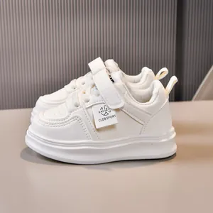 Detail shot of white kids sneaker showing Velcro strap and breathable mesh fabric