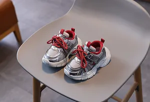 Détail de baskets enfant en mesh argenté avec lacets et doublure rouge vif contrastants