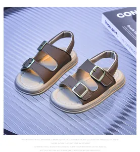 Detailed close-up of brown synthetic leather straps and metal buckles on toddler sandals