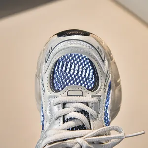 Detailed macro view of the breathable mesh and metallic silver synthetic leather toe cap
