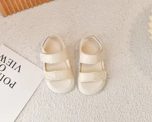 Dettaglio di sandali sportivi da bambino bianco crema con doppi cinturini a strappo
