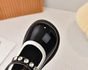 Detalle de zapatos Mary Jane de charol negro para niña con perlas y pedrería brillante