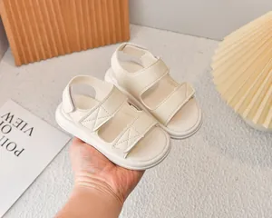 Dettaglio di sandali sportivi crema da bambino con doppie chiusure in velcro e texture PU